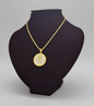Gold necklace with a round pendant on a black mannequin bust against a gray background