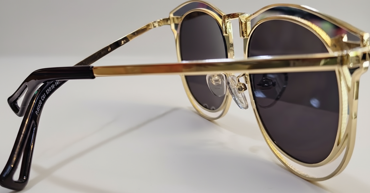 Gold-framed sunglasses with reflective lenses on a transparent background